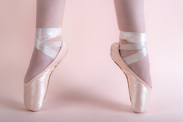 young ballerina on pink ballet pointe shoes in second position