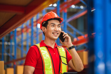 Cheerful warehouse worker with smartphone and digital tablet checking inventory in warehouse, Worker man working in warehouse