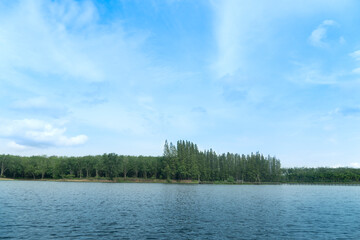 Landscape view of nature Reservoir with light waves. Along the wooden bridge is far away in the tourist attraction. with green trees for backgound under blue sky.