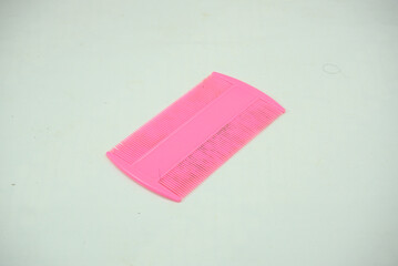 A pink comb on a white background
