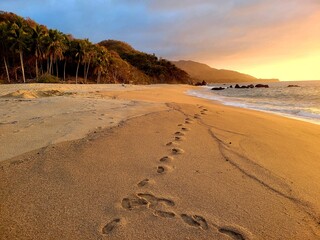 Footprint on beach at sunset