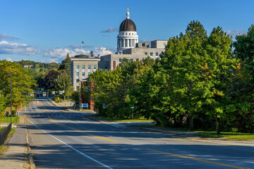 Capitol Street - A sunny Autumn sunday afternoon view of quiet Capitol Street at Downtown Augusta, with the dome of Maine Capitol Building towering in background. Augusta, Maine, USA. - obrazy, fototapety, plakaty