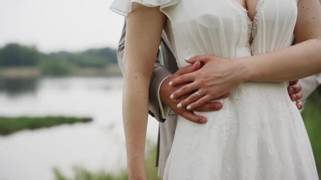 Wedding couple embracing by the river during a photo video session