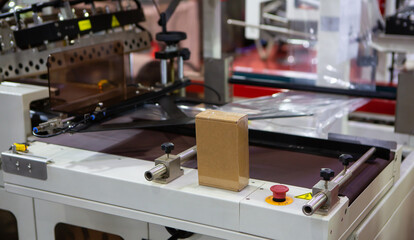 Shrink film package wrapping machine. Wraping packaging of box. Industrial warehouse.