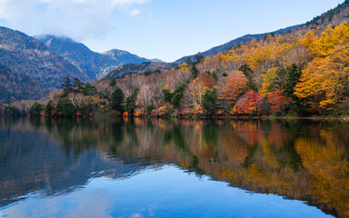 Fototapeta na wymiar Beautiful autumn landscape with reflection against blue sky. Colorful mountain at Nikko, Japan.