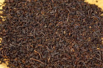 Dry black tea leaves close up. Dark background. Food and drink cooking. Texture