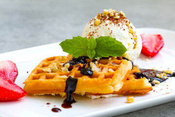 ice cream with Belgian waffles, strawberries, fresh mint, chocolate topping and nuts