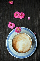 cup of coffee and plum flowers on the table