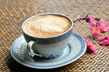 cup of coffee and plum flowers on the table