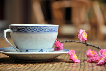 cup of coffee and plum flowers on the table