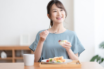 Obraz na płótnie Canvas 朝食を食べる女性