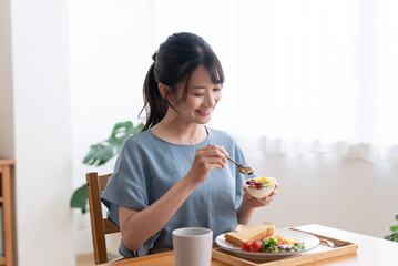 Obraz na płótnie Canvas 朝食を食べる女性