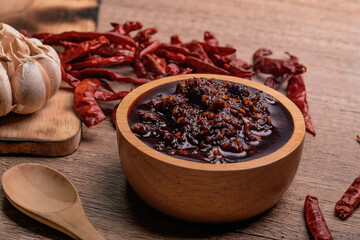 Thai spicy chili paste in a wooden cup (nampnikpao)