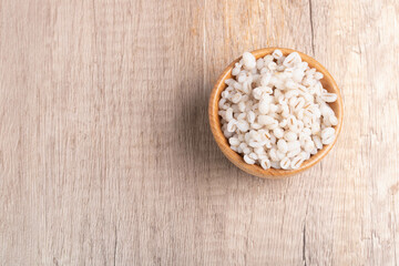 Job's tears boiled in a cup with a wooden spoon. Healthy whole grains.