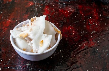 Organic Coconut Pulp in a White Bowl Isolated on Reddish Background with Copy Space