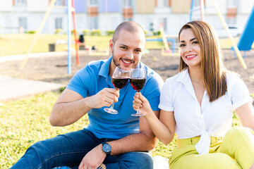 Young couple drinking wine in glasses at a picnic