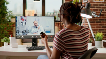 Fototapeta na wymiar African american woman meeting with medic on videocall, attending telemedicine videoconference with webcam to discuss about healthcare and treatment. Online telehealth conference.
