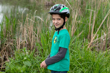 boy in a bicycle helmet outdoors in summer