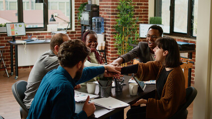 Fototapeta premium Cheerful business people celebrating successful partnership, feeling happy about presentastion success. Smiling coworkers enjoying collaboration agreement, teamwork in boardroom.