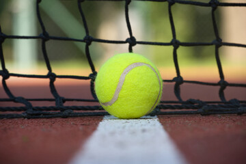 Tennis scene with black net, ball on white line