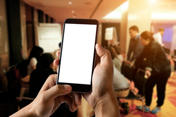 A man hand holding smart phone device in meeting room