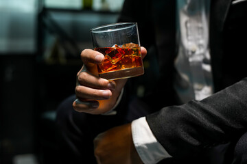 Closeup businessmen holding a glass of whiskey