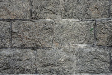 The antique wall is paved with gray stones, top view. stone texture, outdoor stone tiles