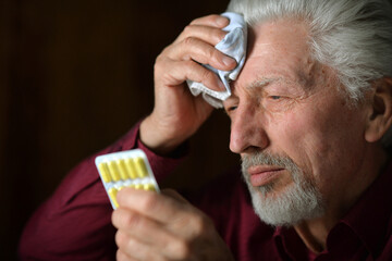 Portrait of sick elderly man with pills