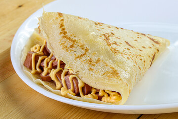 Pancake with sliced sausage and mustard