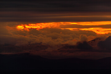 Bright dawn in the sea. Beautiful scarlet and red clouds during a colorful sunrise in Vladivostok.