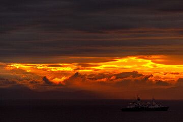 Bright dawn in the sea. Beautiful scarlet and red clouds during a colorful sunrise in Vladivostok.