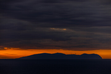 Bright dawn in the sea. Beautiful scarlet and red clouds during a colorful sunrise in Vladivostok.