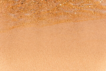 Soft beautiful sea wave on sandy beach. Water bright background.Top view.Copy space.