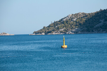 Fototapeta premium Yellow Sea Buoy in turquoise water of Mediterranean Sea. Marine Navigation Buoy. Safe water mark