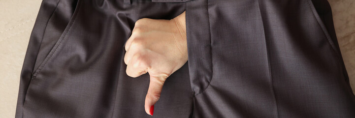 Woman show thumbs down gesture through mans pants