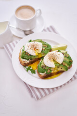 Freshly made poached egg and Avocado toasts on light grey background