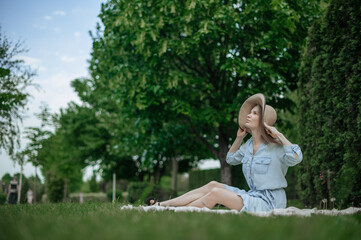 Naklejka premium Romantic girl with hat on picnic in park