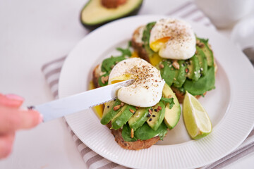 Freshly made poached egg and Avocado toasts on light grey background