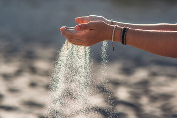 Sand läuft durch die Hände, Symbol für Zeit, Vergänglichkeit. Selektive Schärfe