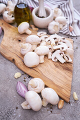 champignon mushrooms on wooden cutting board at domestic kitchen