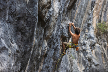 Strong man climbing a rock.