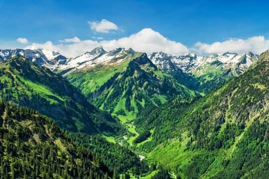 Alpine landscape with snowy mountains and green valley at a beautiful summer day. Allgau Alps, Bavaria, Germany, Europe
