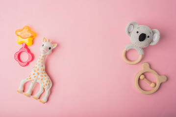 Baby rattle toys on pink background