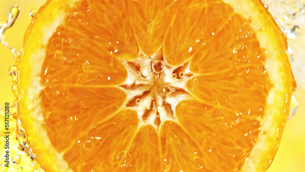 Poster Slice of orange with water splashes on colored background.