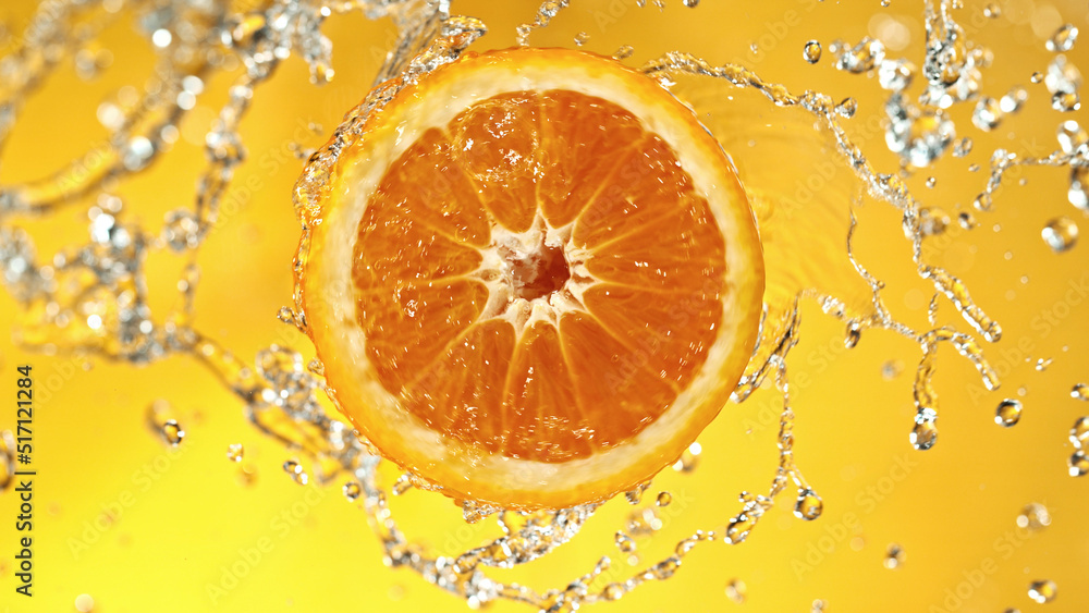 Poster slice of orange with water splashes on colored background.