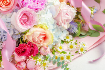 Flower bouquet with roses and pink ribbon