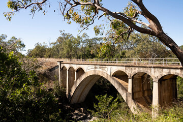 Old disused and abandoned concrete railway bridge with arches built in 1905 at Chowey on the old Biggenden to Gayndah line in Queensland, Australia.