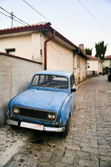 Ohrid, Macedonia - May 15, 2021: Retro vintage old blue car parking on a cobblestone street in Ohrid Old Town, North Macedonia. High quality photo