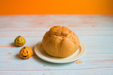 シュークリームとかぼちゃと木製テーブルとオレンジ背景の写真