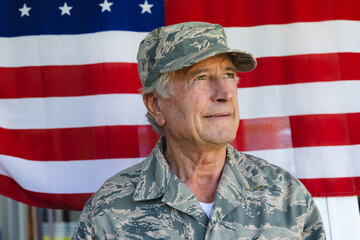 Close-up of caucasian army soldier wearing camouflage clothing looking away against flag of america